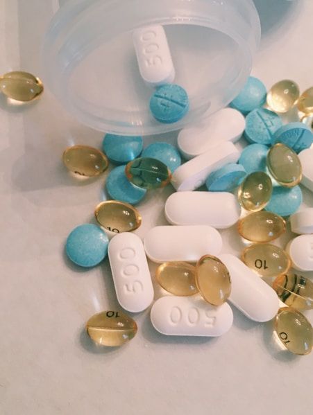 Capsules and tablets spilled across a pale surface.
