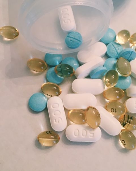 Capsules and tablets spilled across a pale surface.