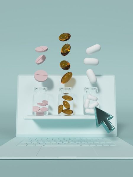 Illustration of pills falling into a laptop screen, with a cursor beside it.