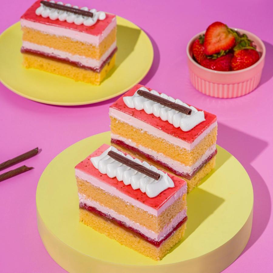 Strawberry layer pastries on yellow plates with fresh strawberries