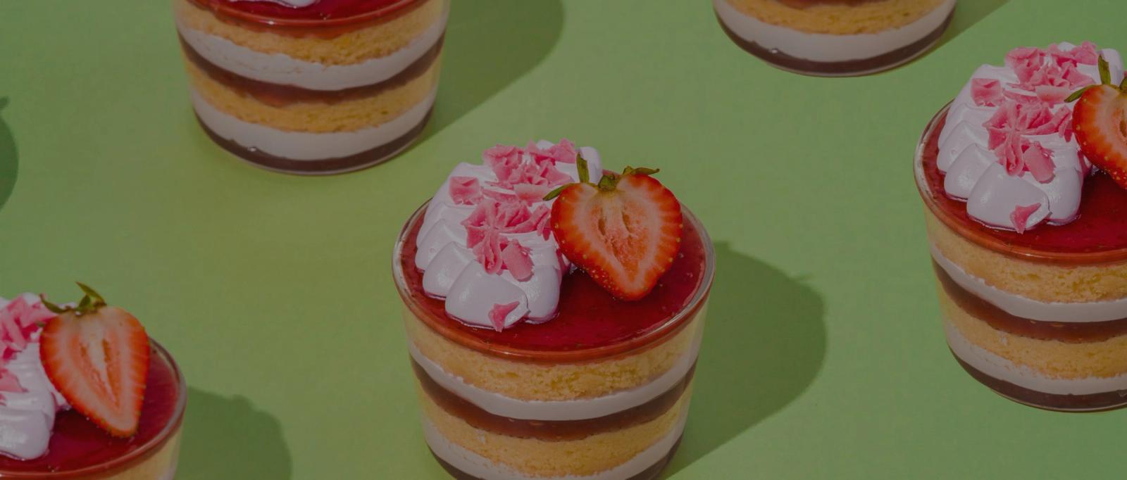 Strawberry cake cups on a green background