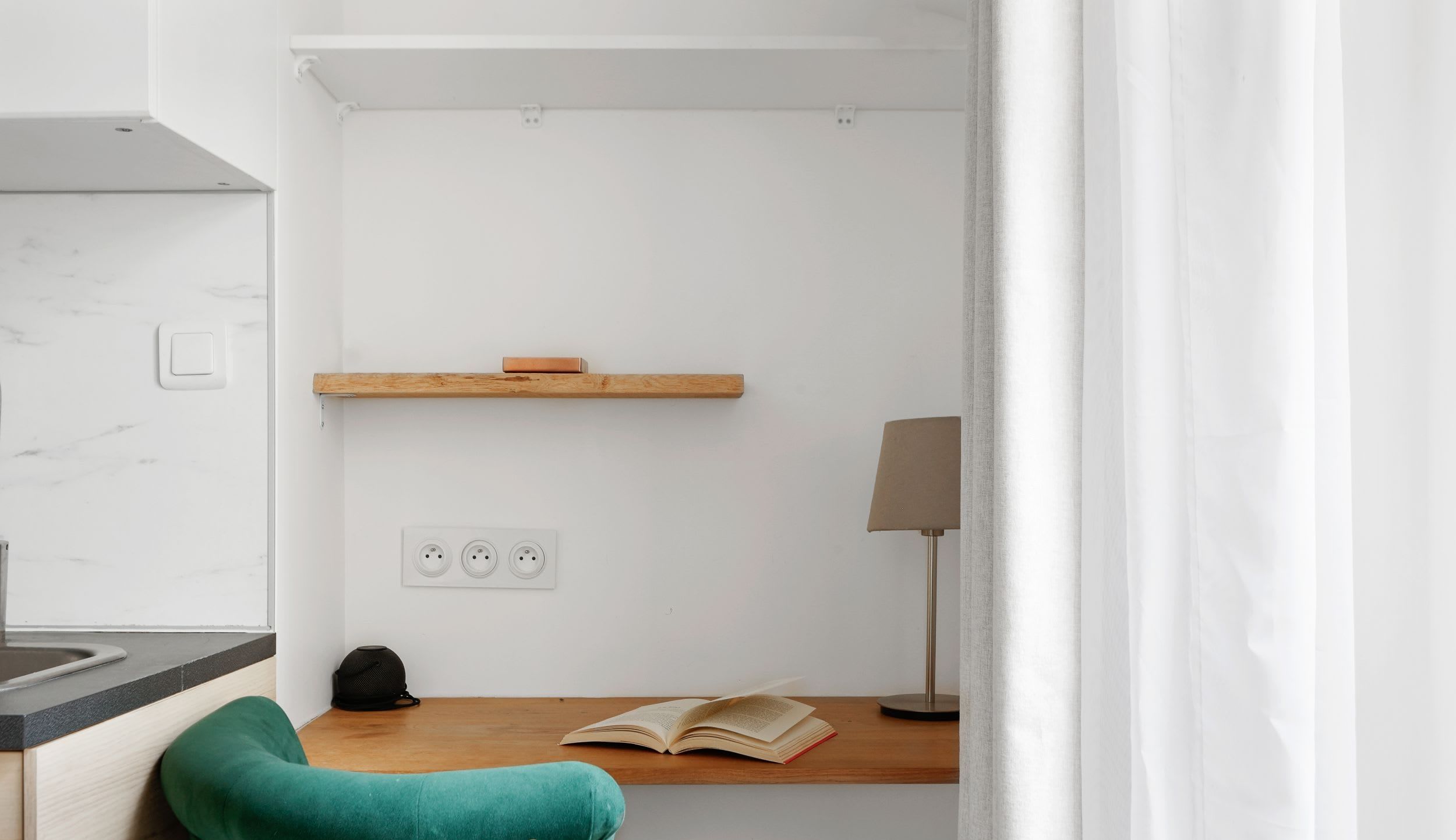 Appartement meublé rue Saint-Séverin Paris 5e, canapé-lit sous des poutres apparentes dans un intérieur du Quartier Latin