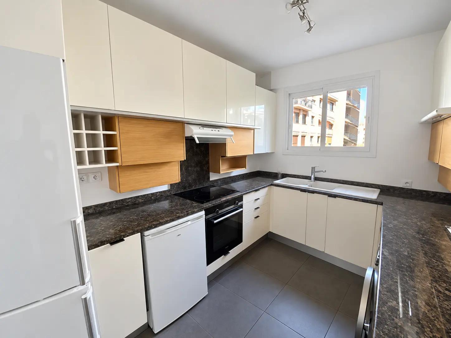 Bright fitted kitchen with oven, fridge and ample storage