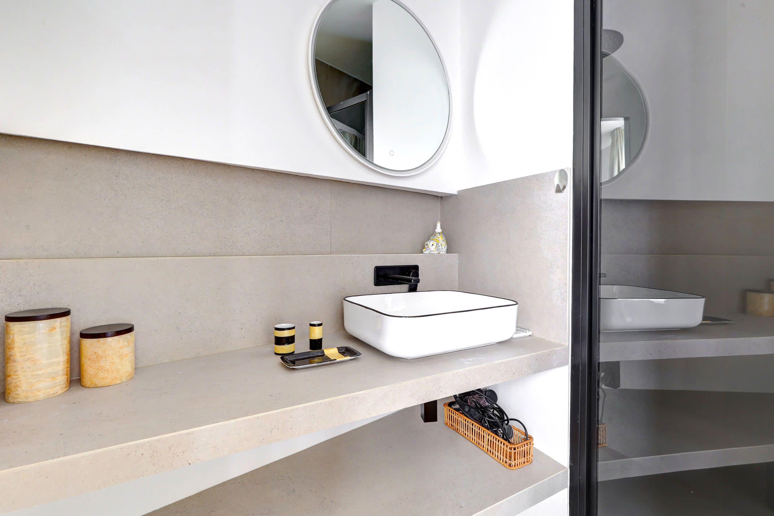 Salle de bain : douche, évier, lavabo, miroir et toilette.