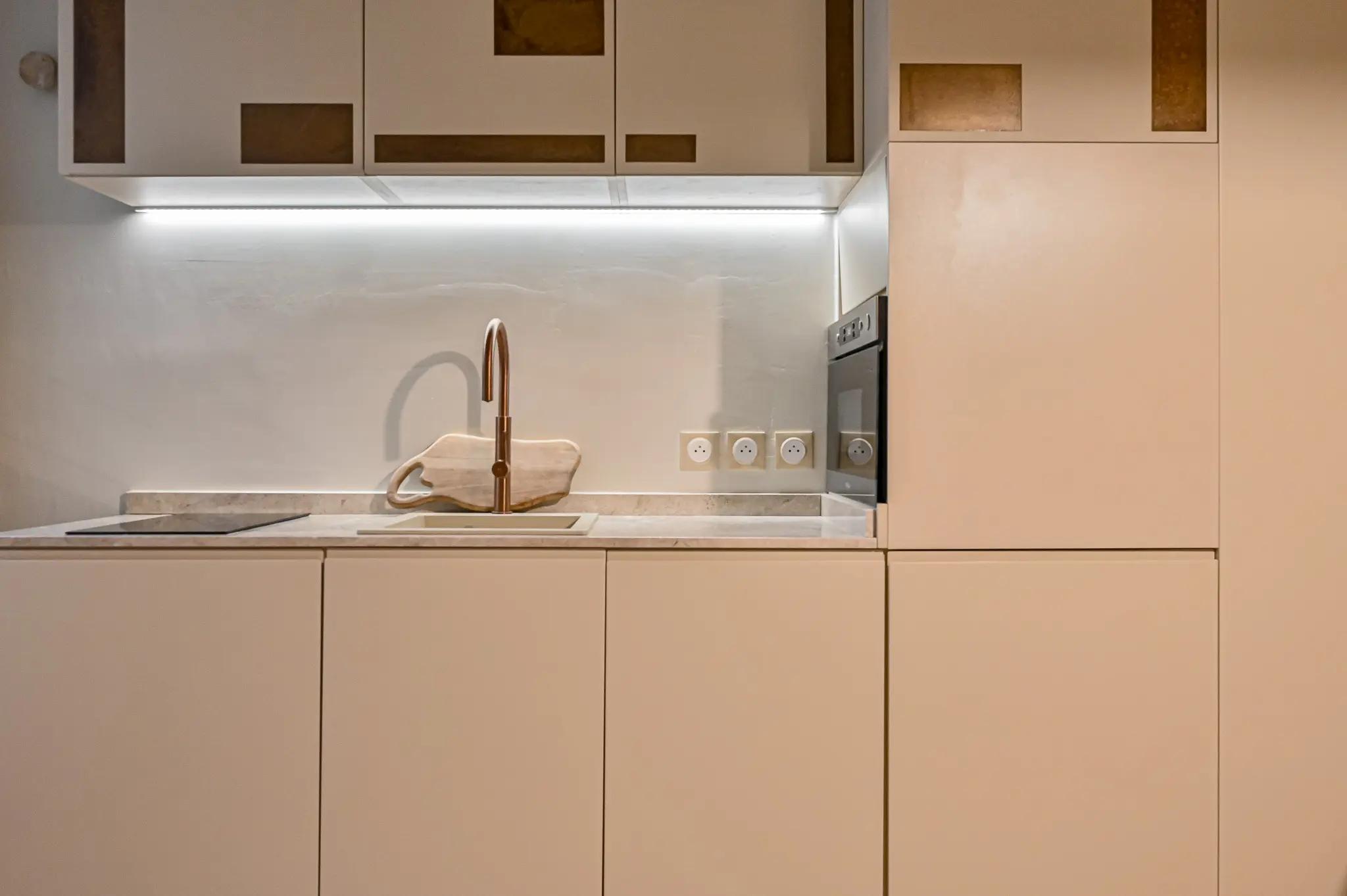 Kitchenette intégrée avec four et éclairage sous meubles