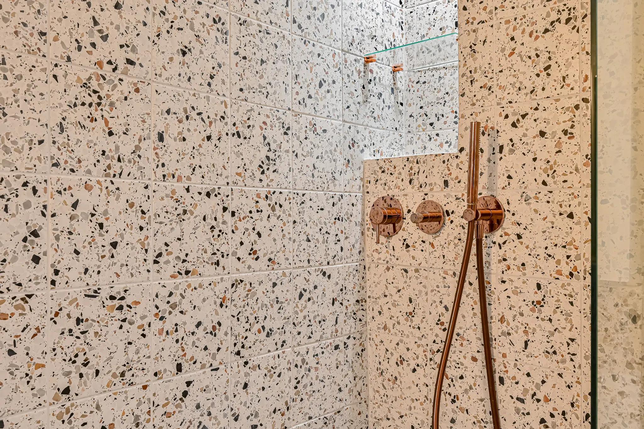 Douche en terrazzo avec robinetterie cuivrée
