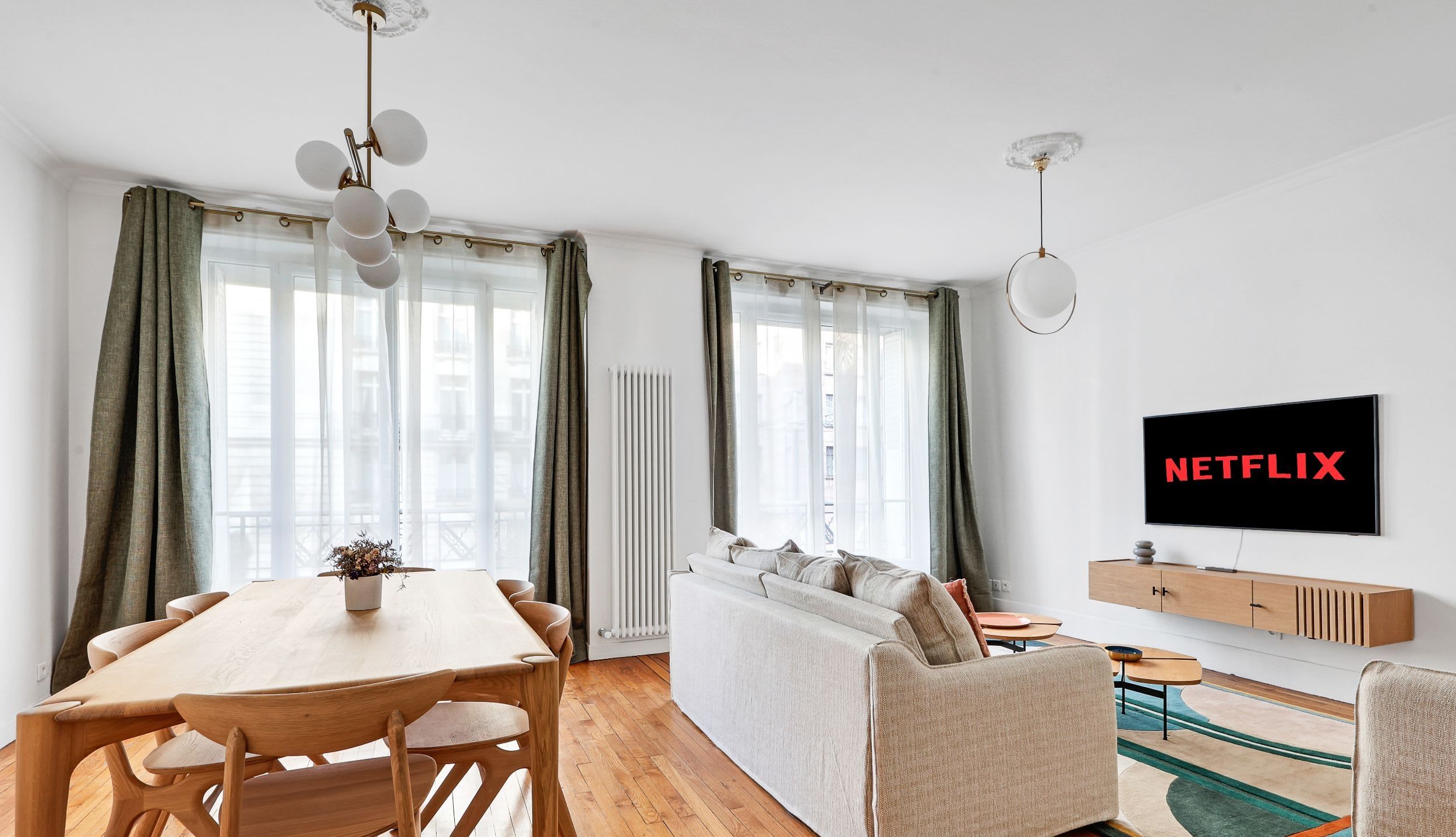 Espace de vie avec canapé confortable, TV connectée et coin repas