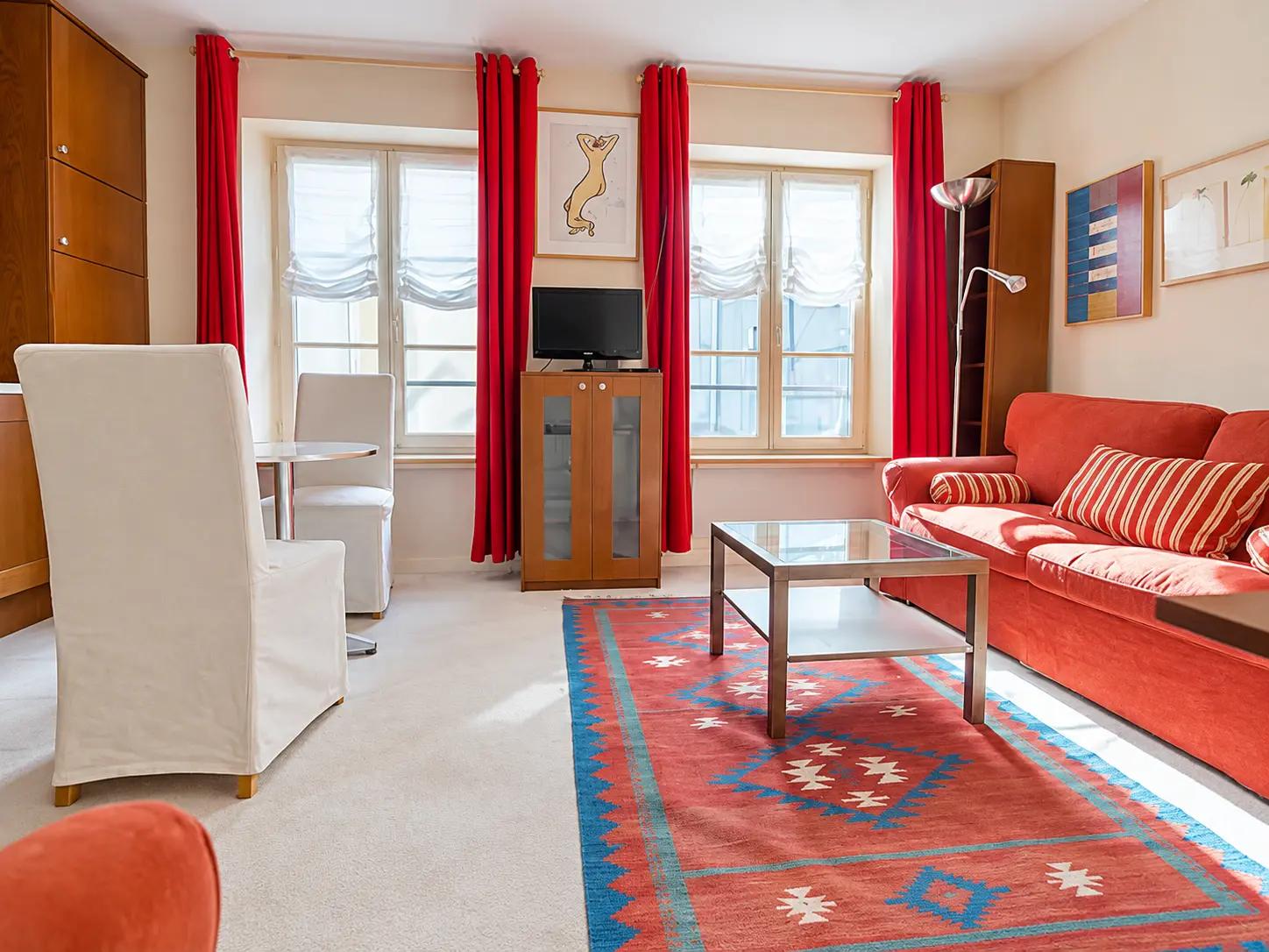 Bright living room with sofa, dining area and large windows