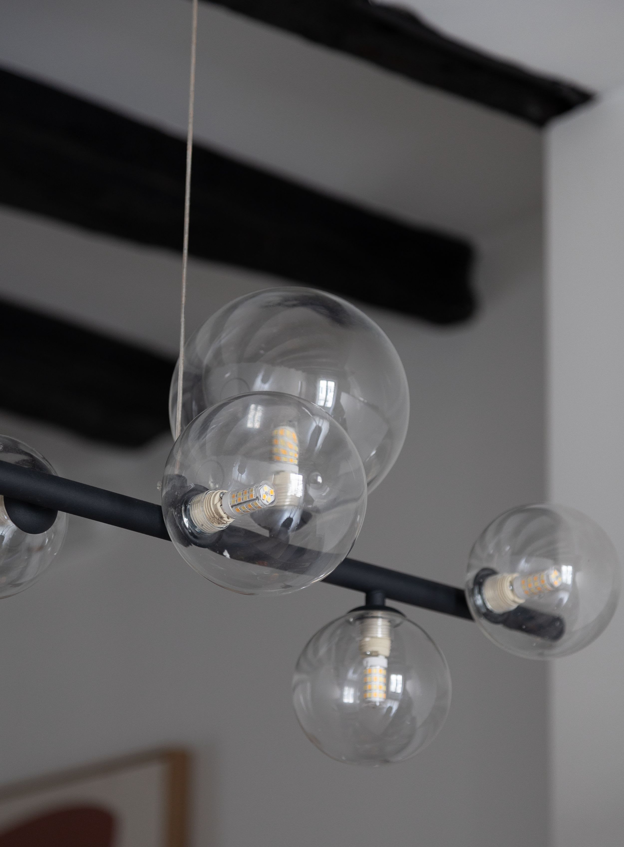 Appartement meublé rue Saint-Séverin Paris 5e, canapé-lit sous des poutres apparentes dans un intérieur du Quartier Latin