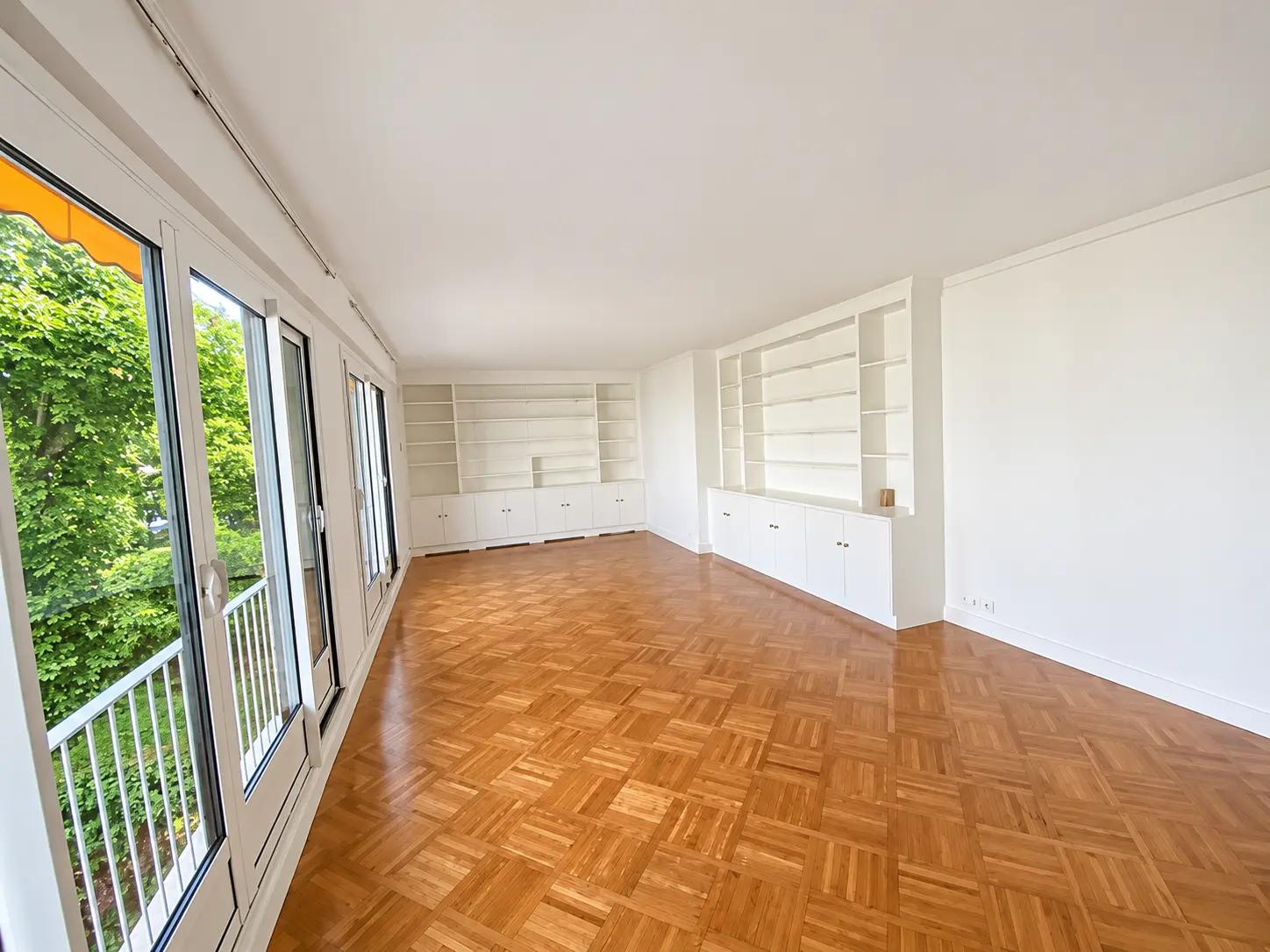 Spacious living room with parquet floors and built-in shelves