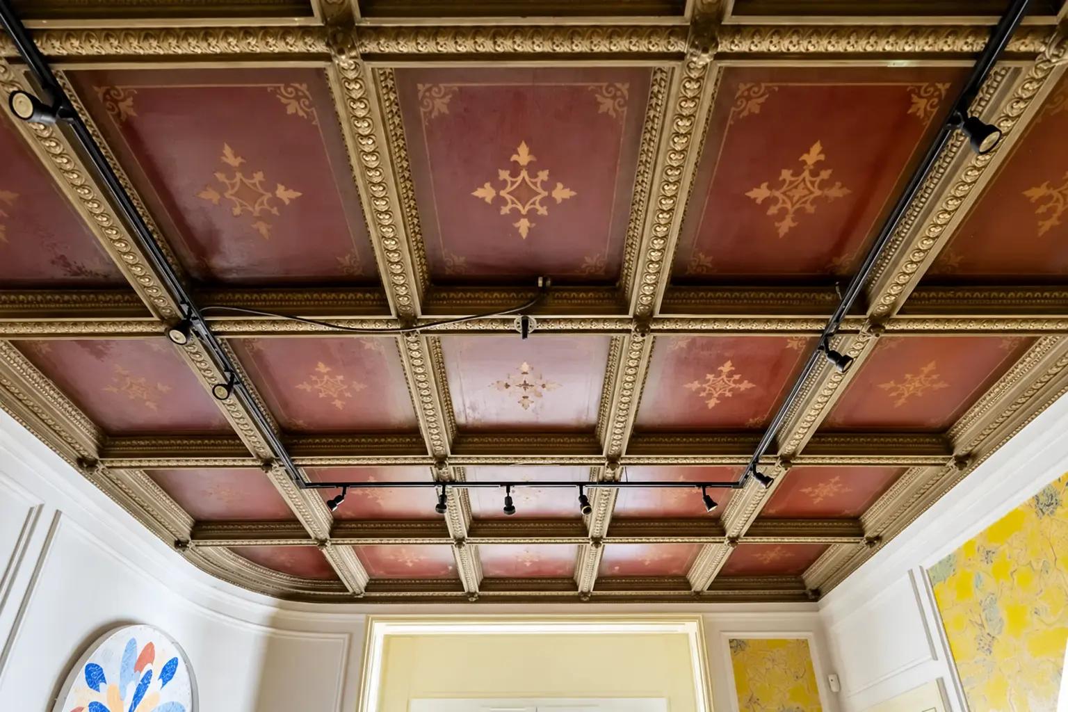 Plafond à caissons rouge et or avec motifs décoratifs