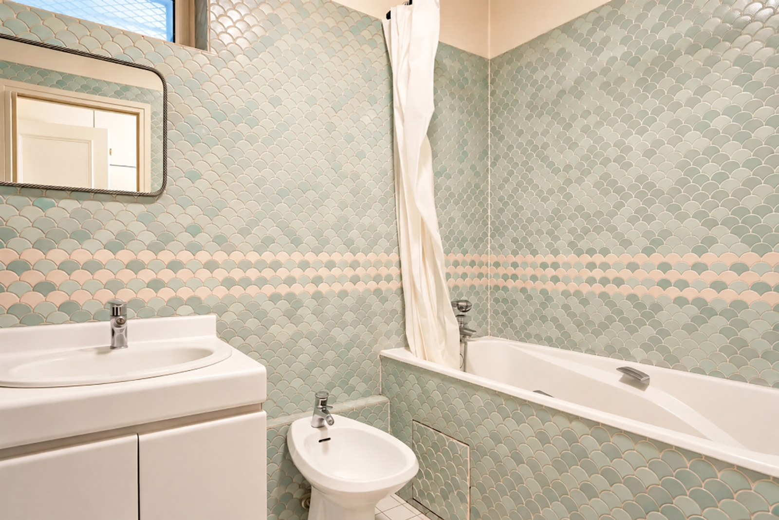 Salle de bains avec baignoire et carrelage vert