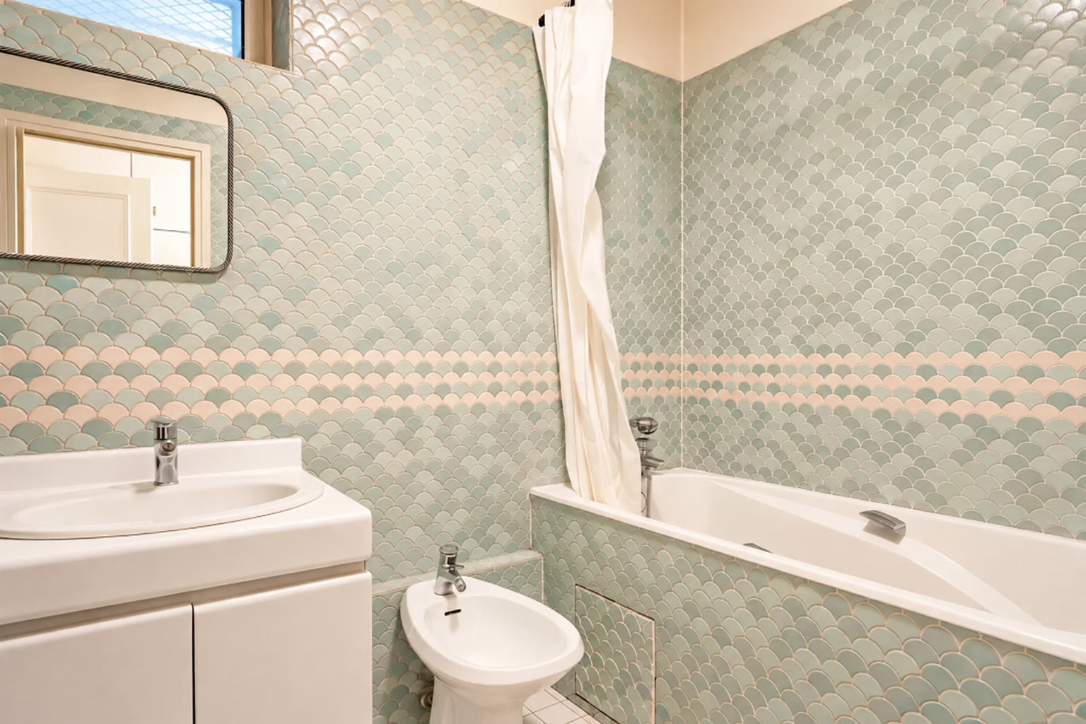 Salle de bains avec baignoire et carrelage vert