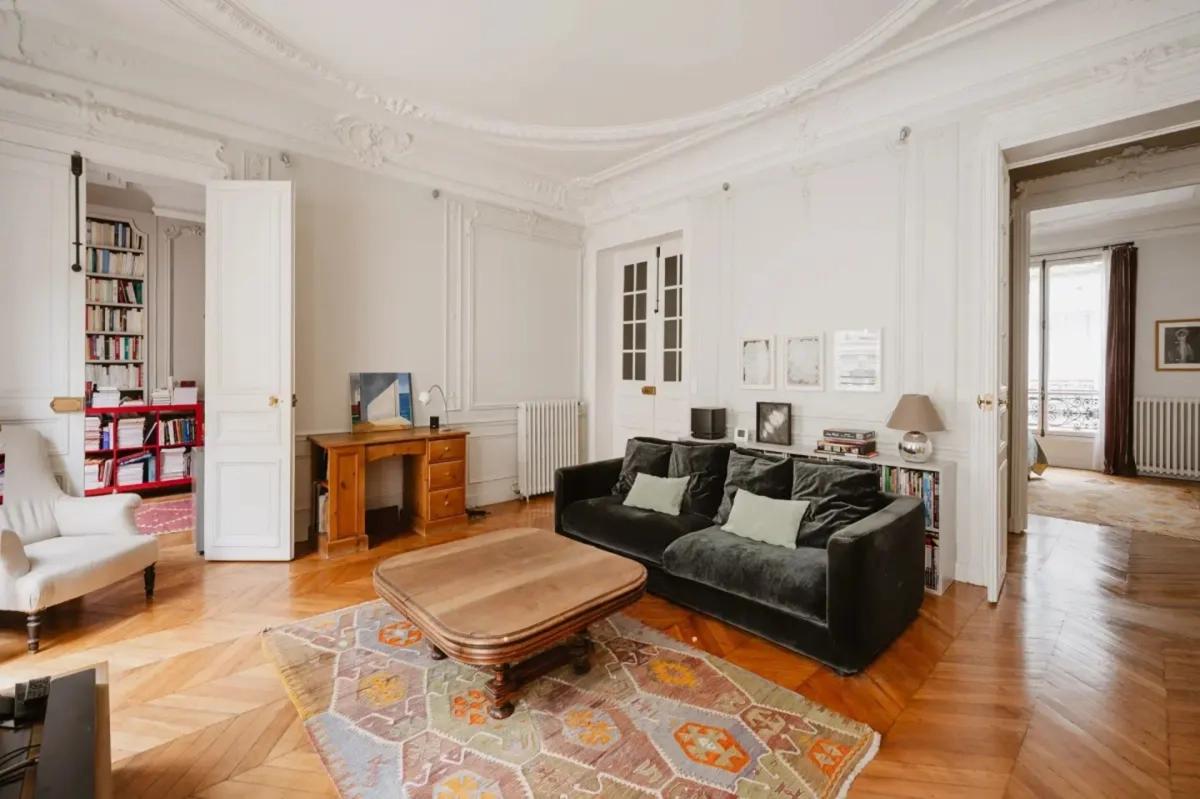 Grand salon avec parquet et belle hauteur sous plafond