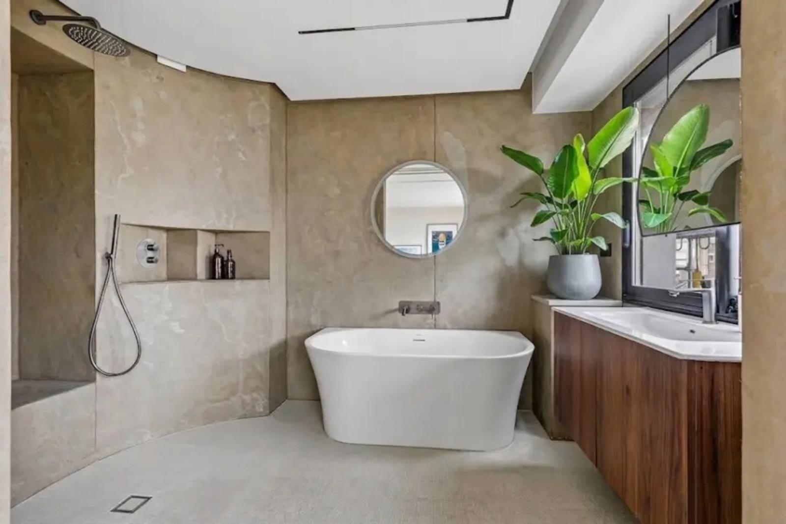 Salle de bains avec baignoire îlot et douche à l’italienne