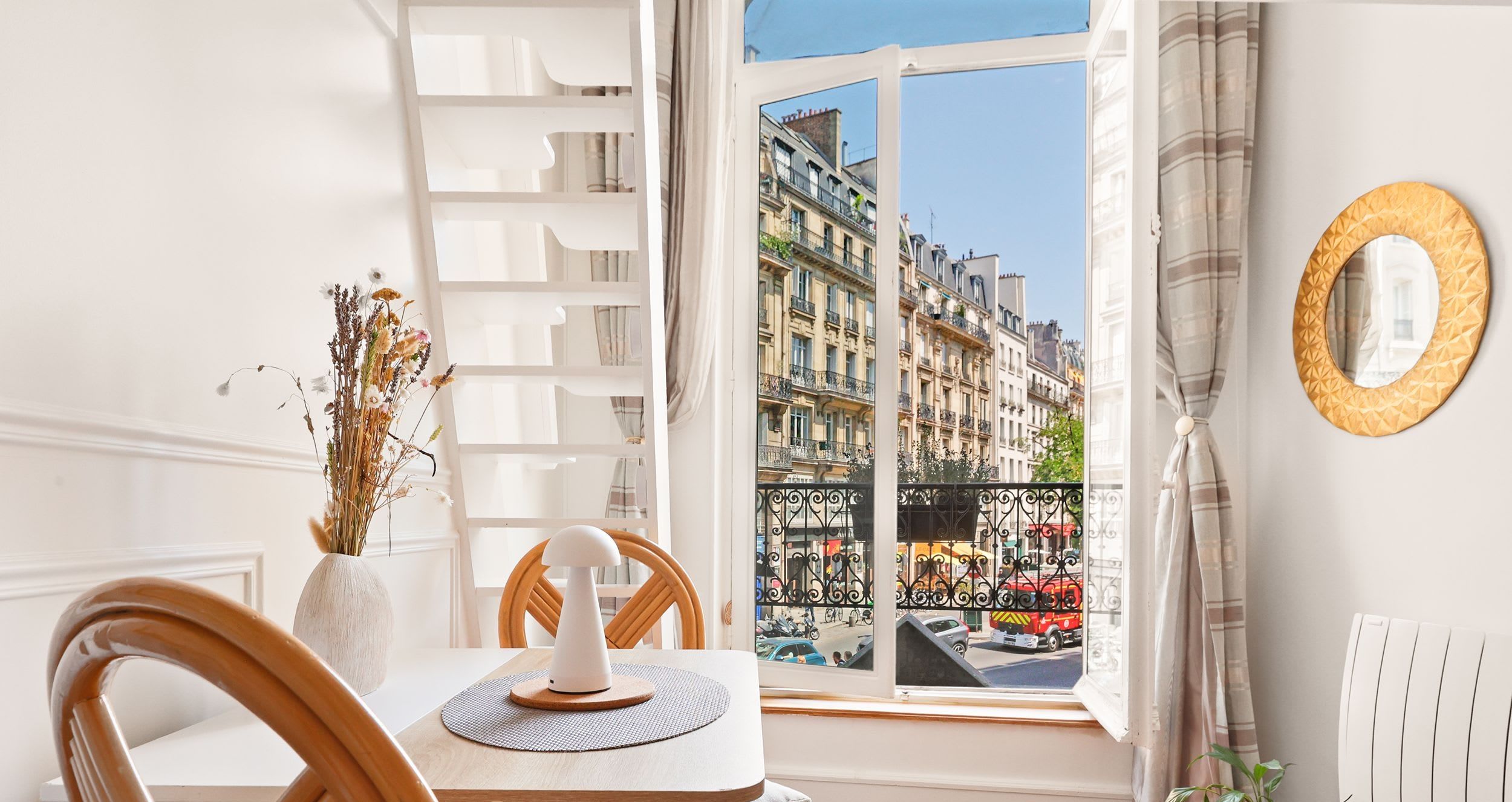 Séjour lumineux avec canapé, cheminée décorative et miroir doré dans un duplex rue Montmartre, Montorgueil, Paris 2e