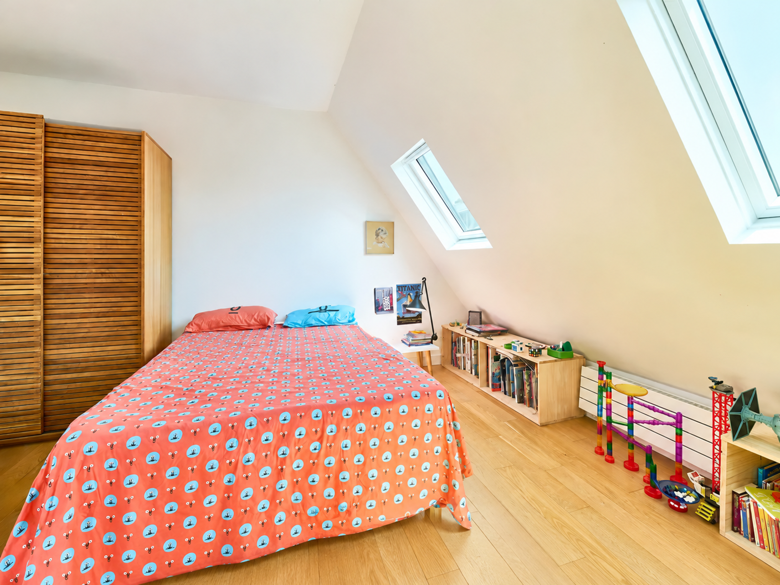 Chambre lumineuse avec fenêtres de toit et parquet