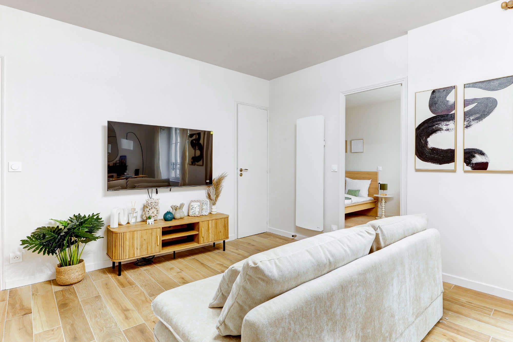 Appartement meublé rénové de 55 m² rue des Tournelles Paris 4e, canapé-lit et coin repas dans un intérieur lumineux du Marais