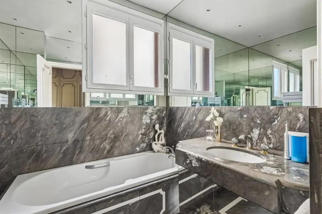 Salle de bains en marbre avec baignoire et miroirs