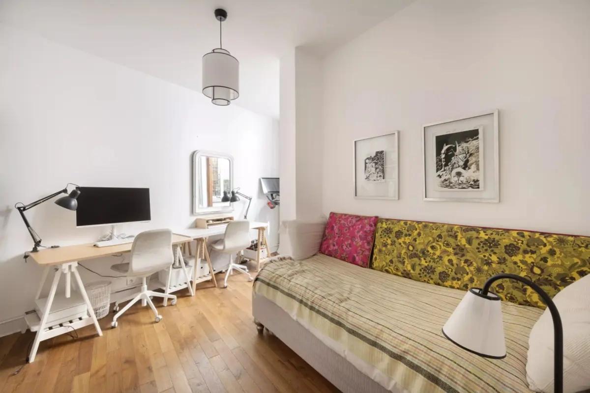 Bureau lumineux avec canapé-lit dans un appartement