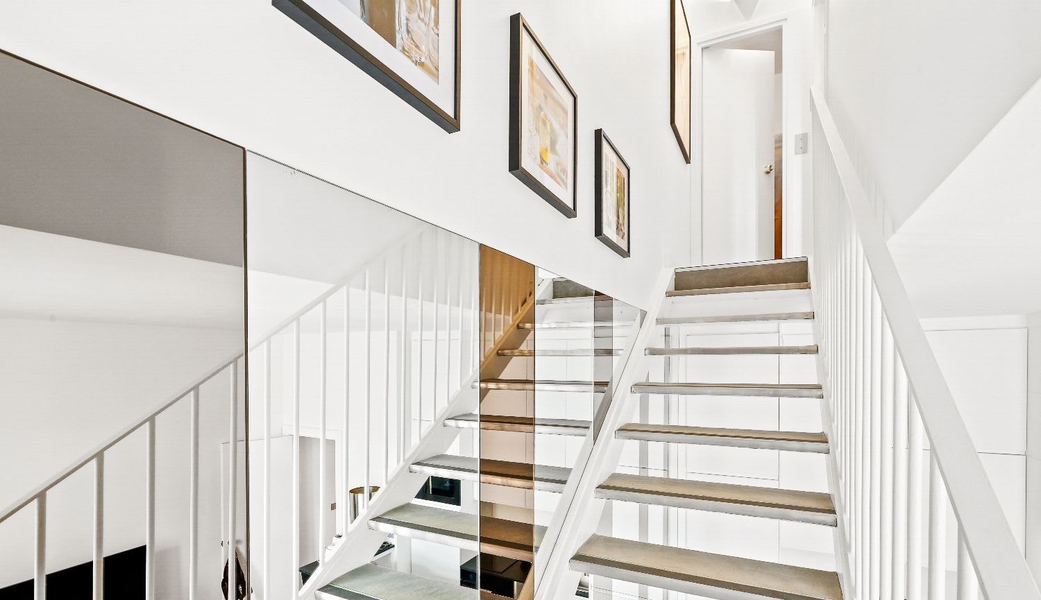 Duplex de luxe Paris 16e, séjour double hauteur avec balcon en fer forgé et vue Tour Eiffel, location meublée moyenne durée