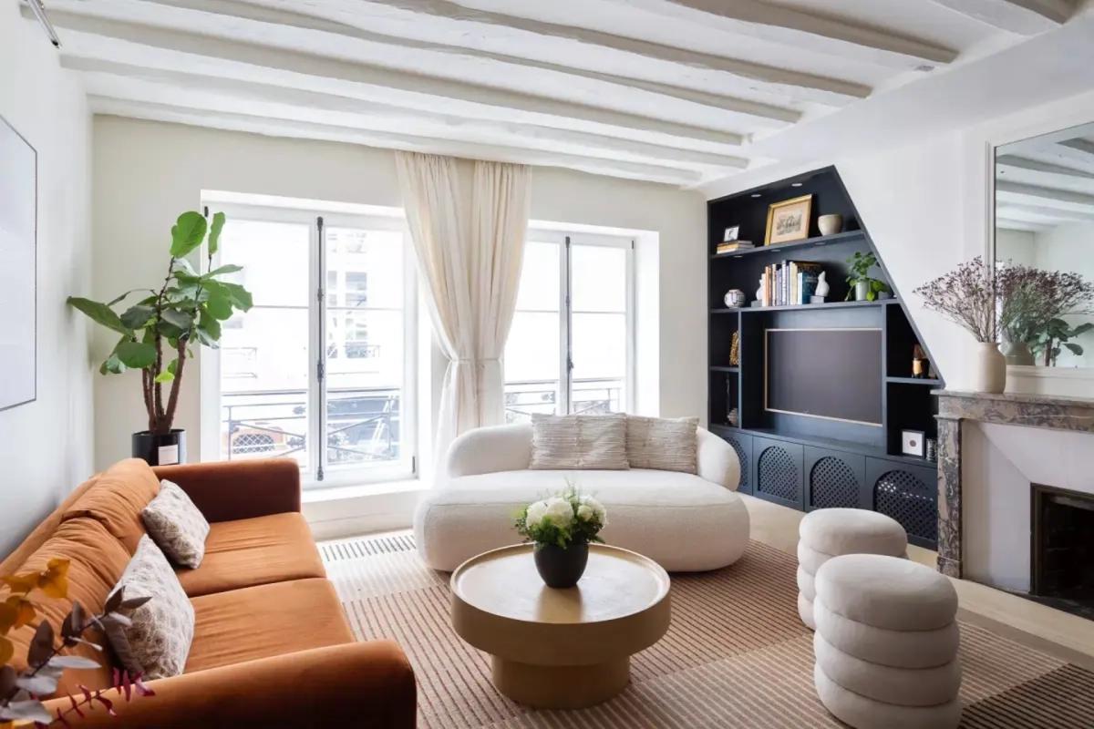 Salon parisien lumineux avec cheminée et bibliothèque