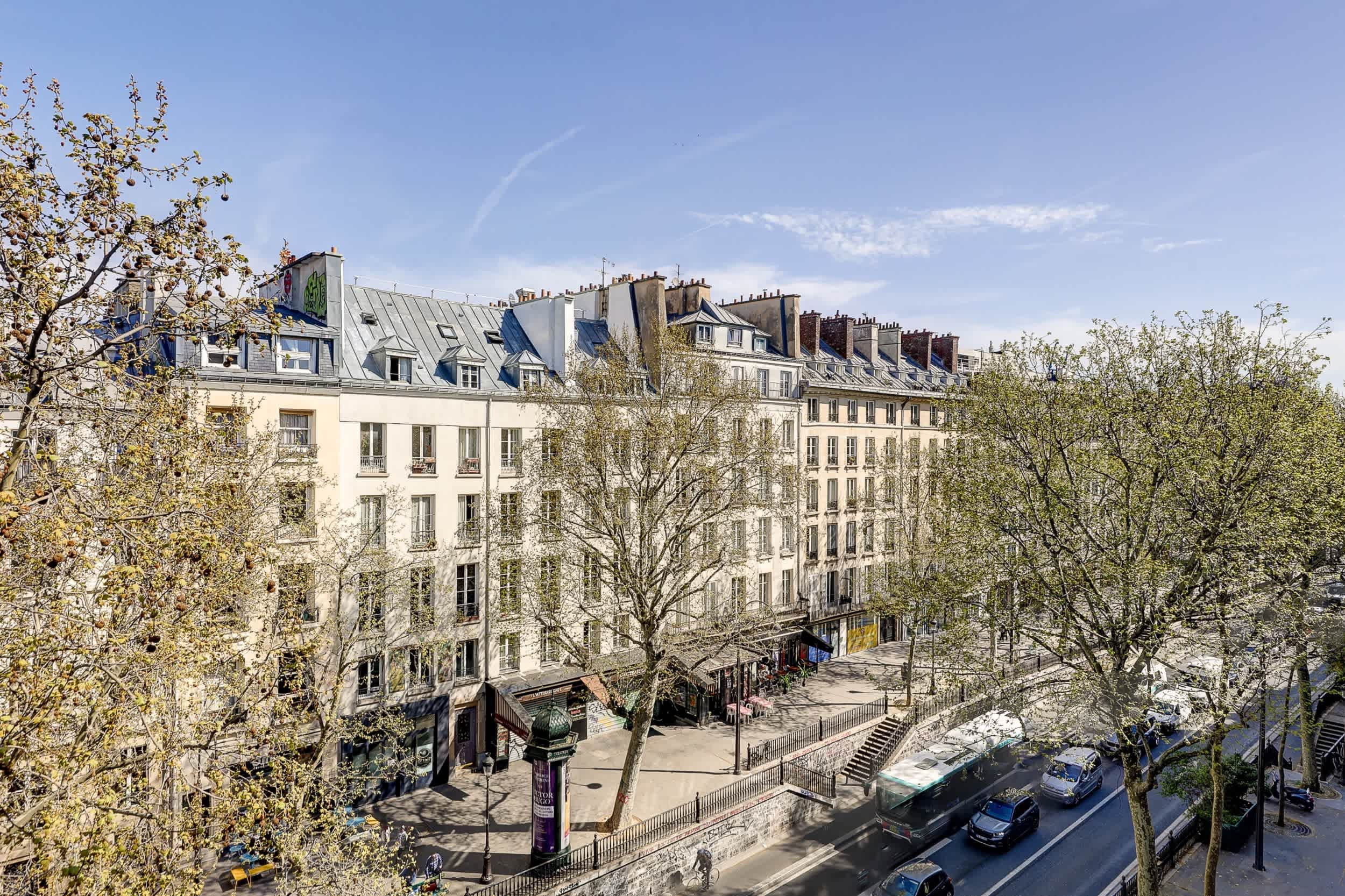 Top-floor Haussmann apartment on rue Meslay near République Paris 3rd, bright dual-aspect living room with designer sofa bed and refined decor