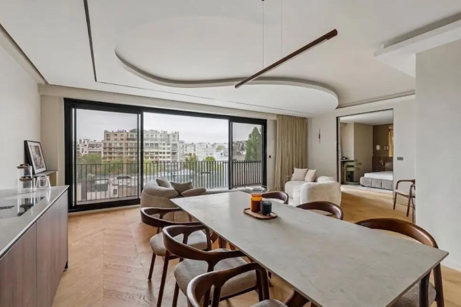 Coin repas face aux grandes baies vitrées et au balcon