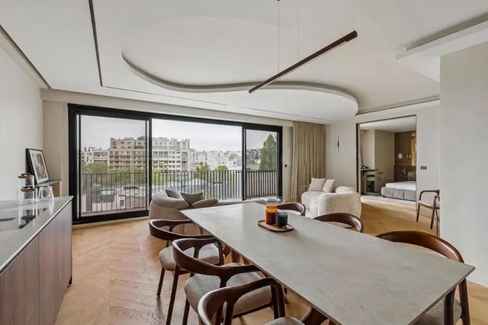 Coin repas face aux grandes baies vitrées et au balcon