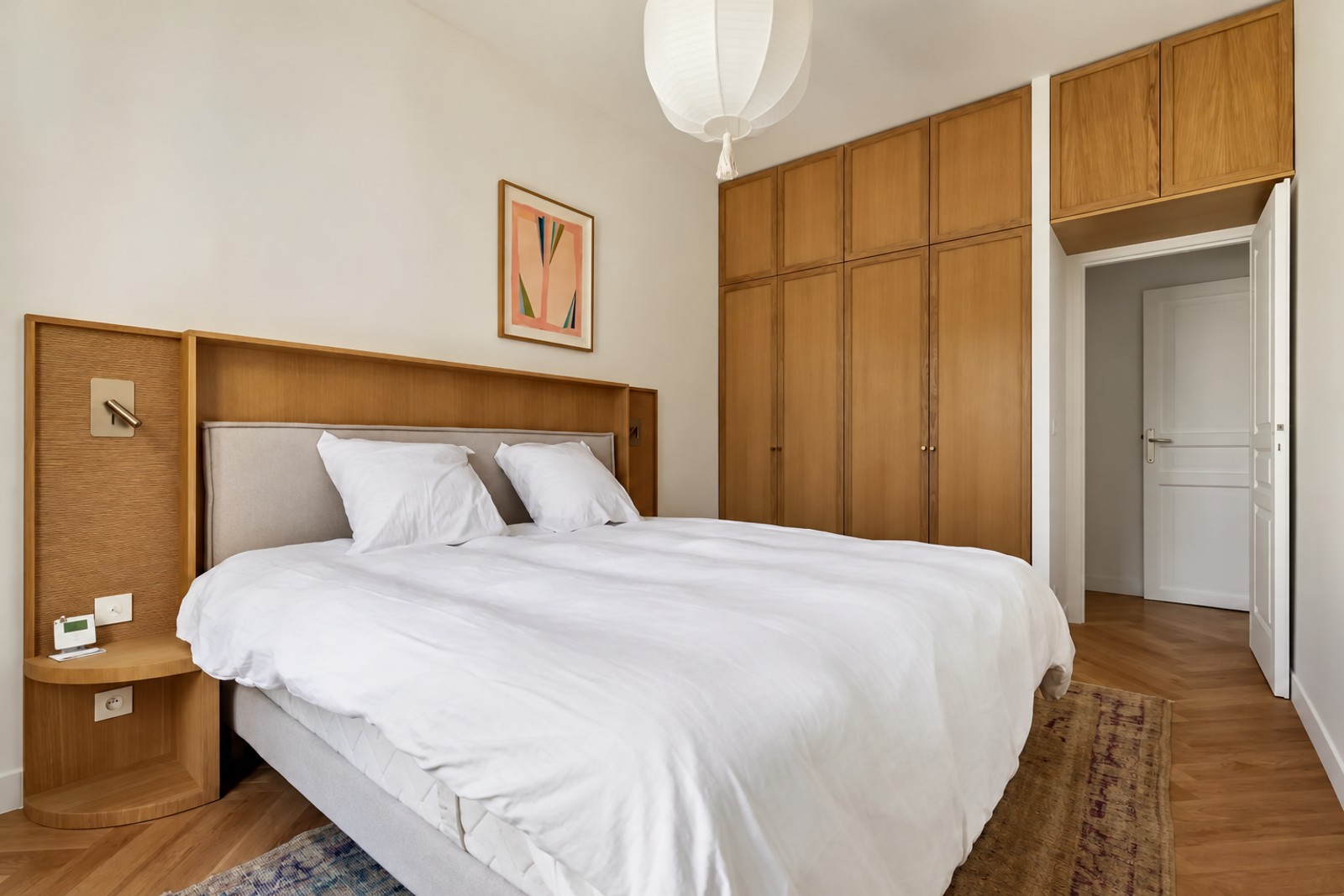 Chambre avec placards en bois et lit double