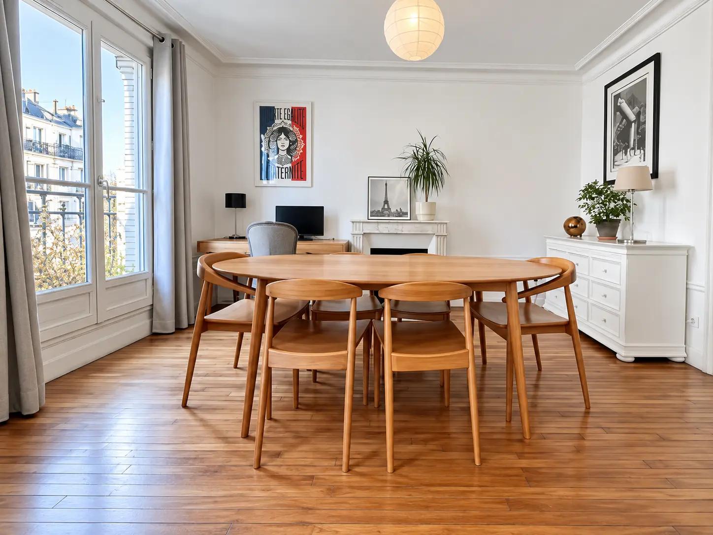 Salle à manger lumineuse avec grandes fenêtres et table en bois