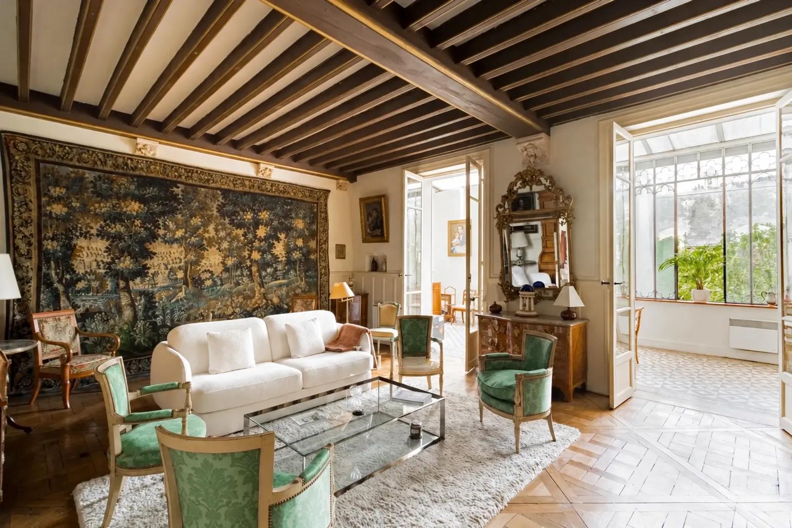 Salon avec poutres apparentes et grande tapisserie