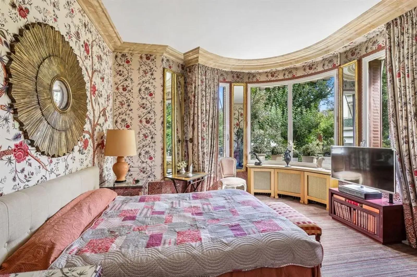Chambre fleurie avec fenêtre arrondie sur la verdure
