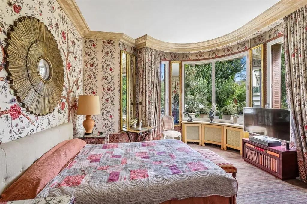 Chambre fleurie avec fenêtre arrondie sur la verdure