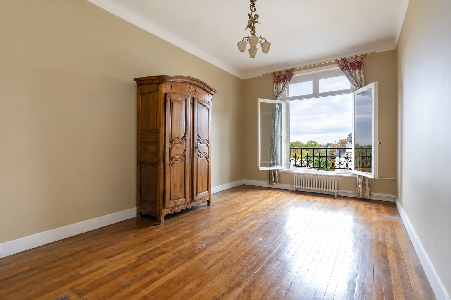 Bedroom with antique wardrobe and large window