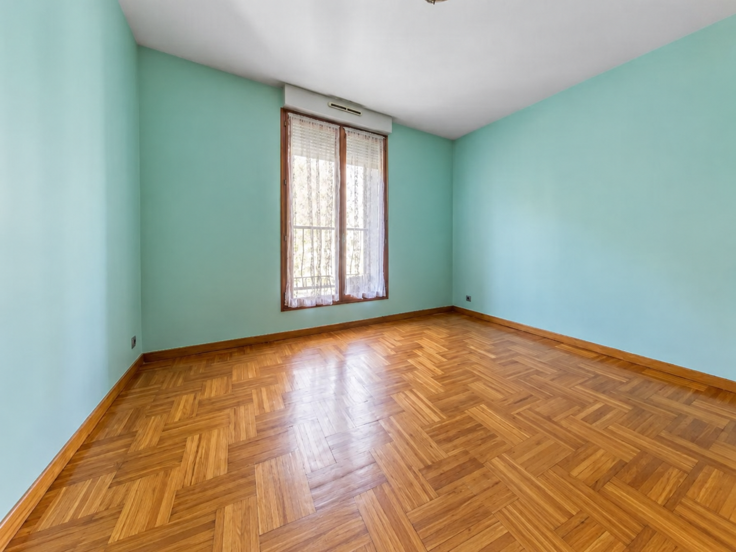 Chambre aux murs verts et parquet à Paris 15
