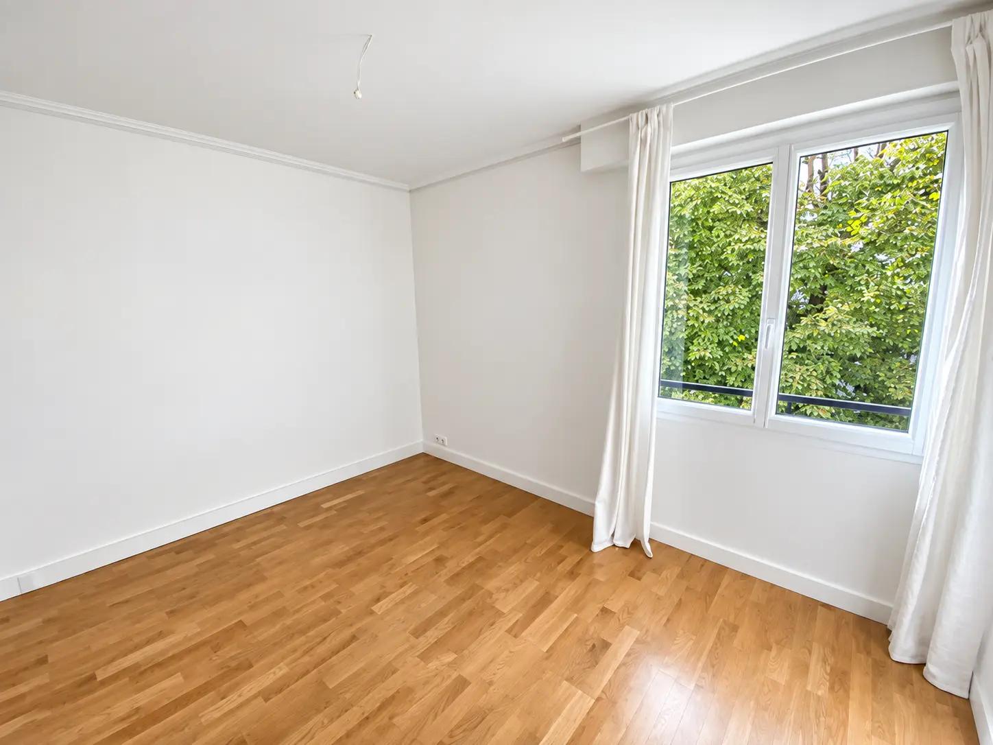 Quiet bedroom with parquet flooring and green garden view