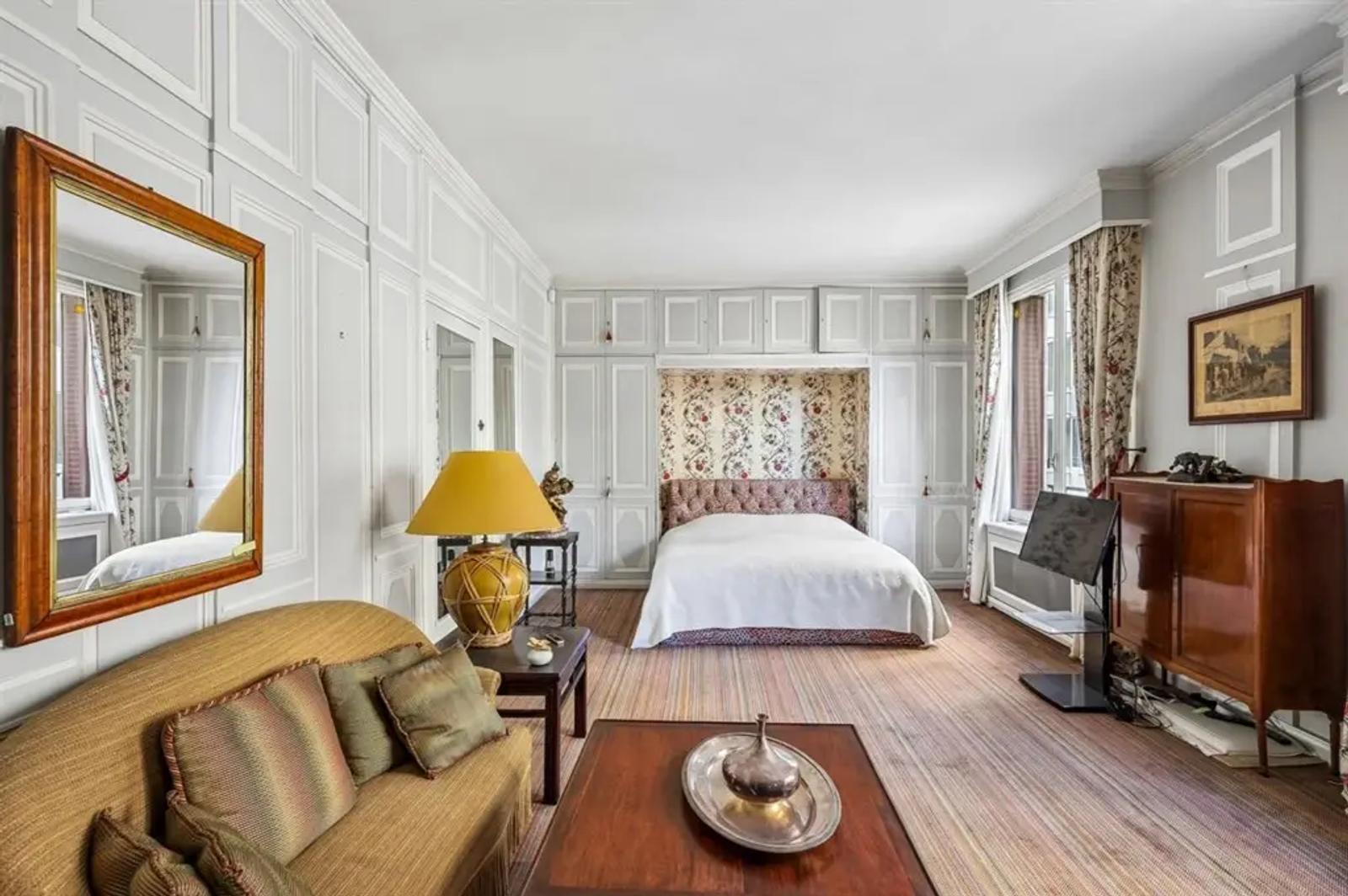 Grande chambre avec panneaux décoratifs et coin salon