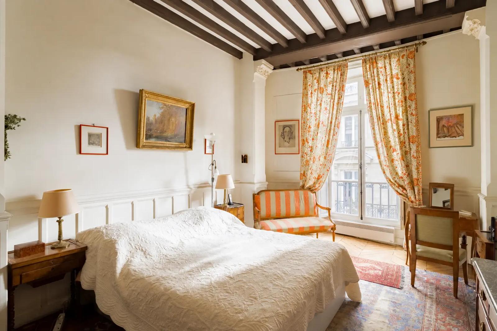 Chambre avec poutres apparentes et rideaux fleuris