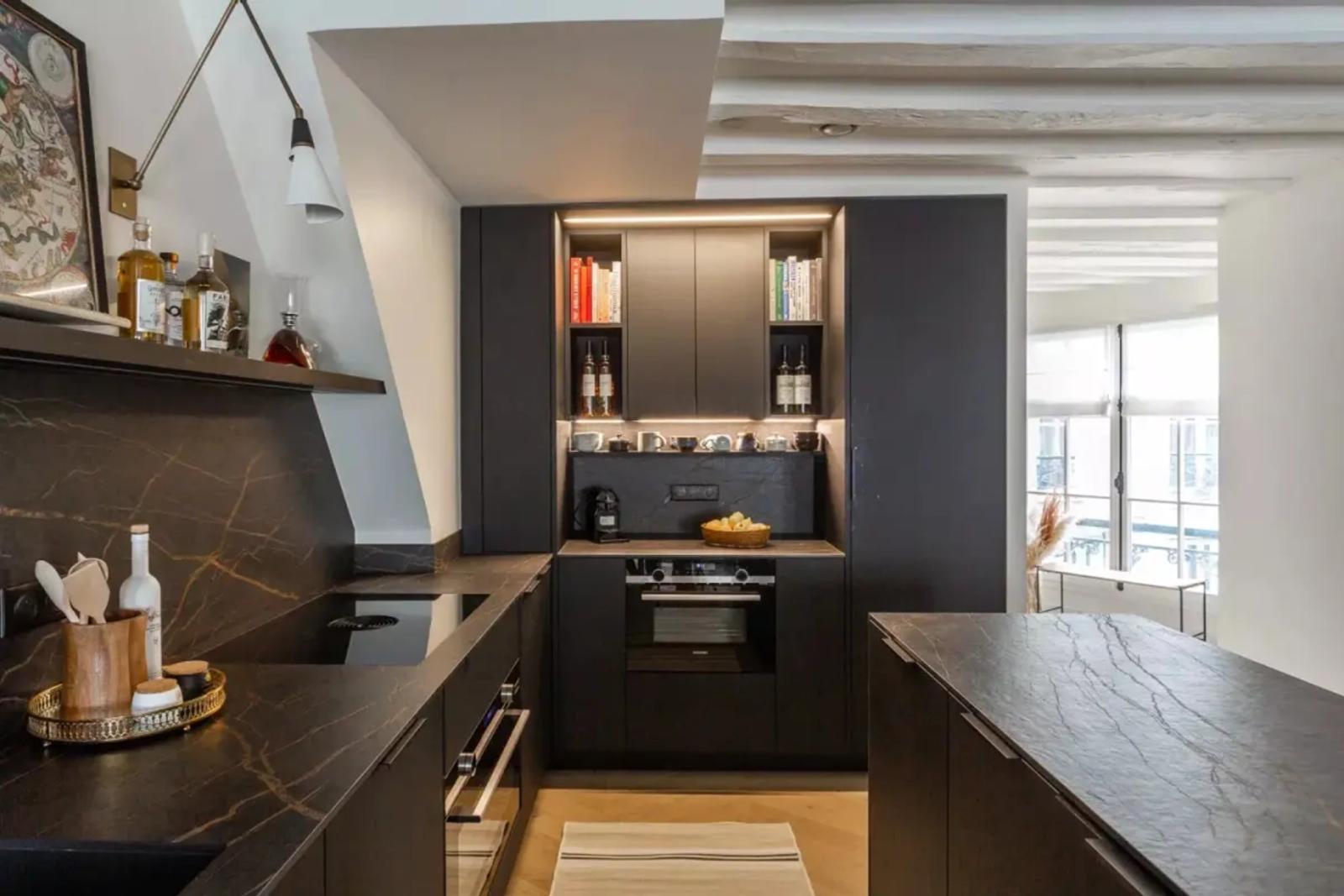 Cuisine noire moderne avec plans de travail en pierre