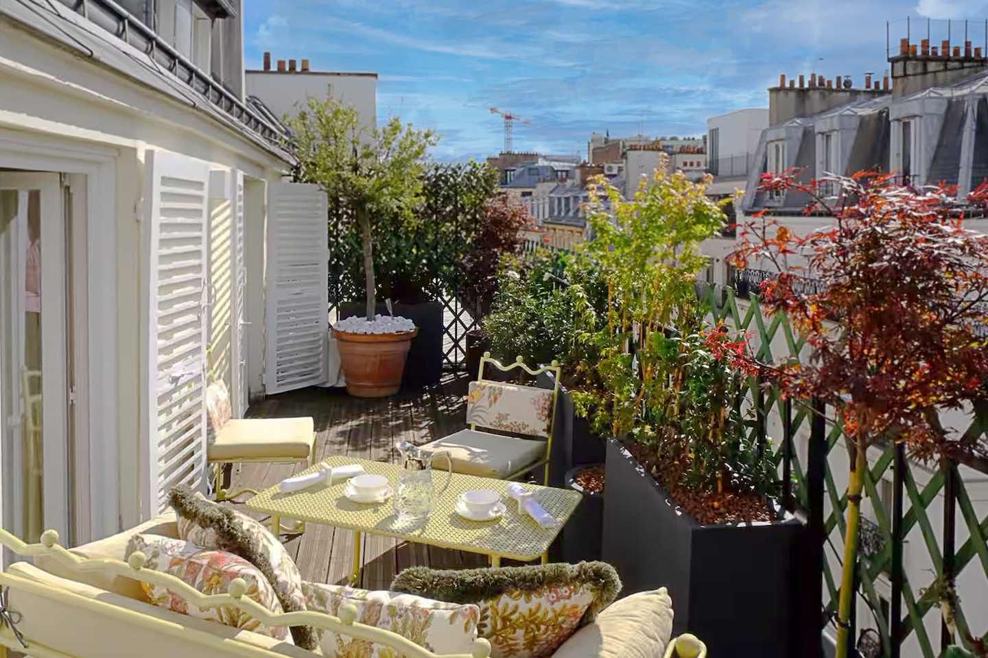 A sun-drenched, flower-filled terrace, perfect for enjoying breakfast outdoors or peaceful evenings in the heart of Paris.