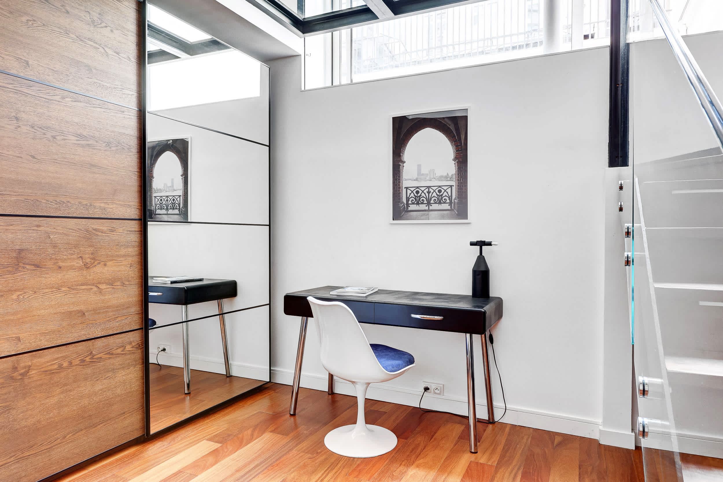Bright architect-designed Paris apartment with a glass roof, modern open living space, sofa, and open kitchen.