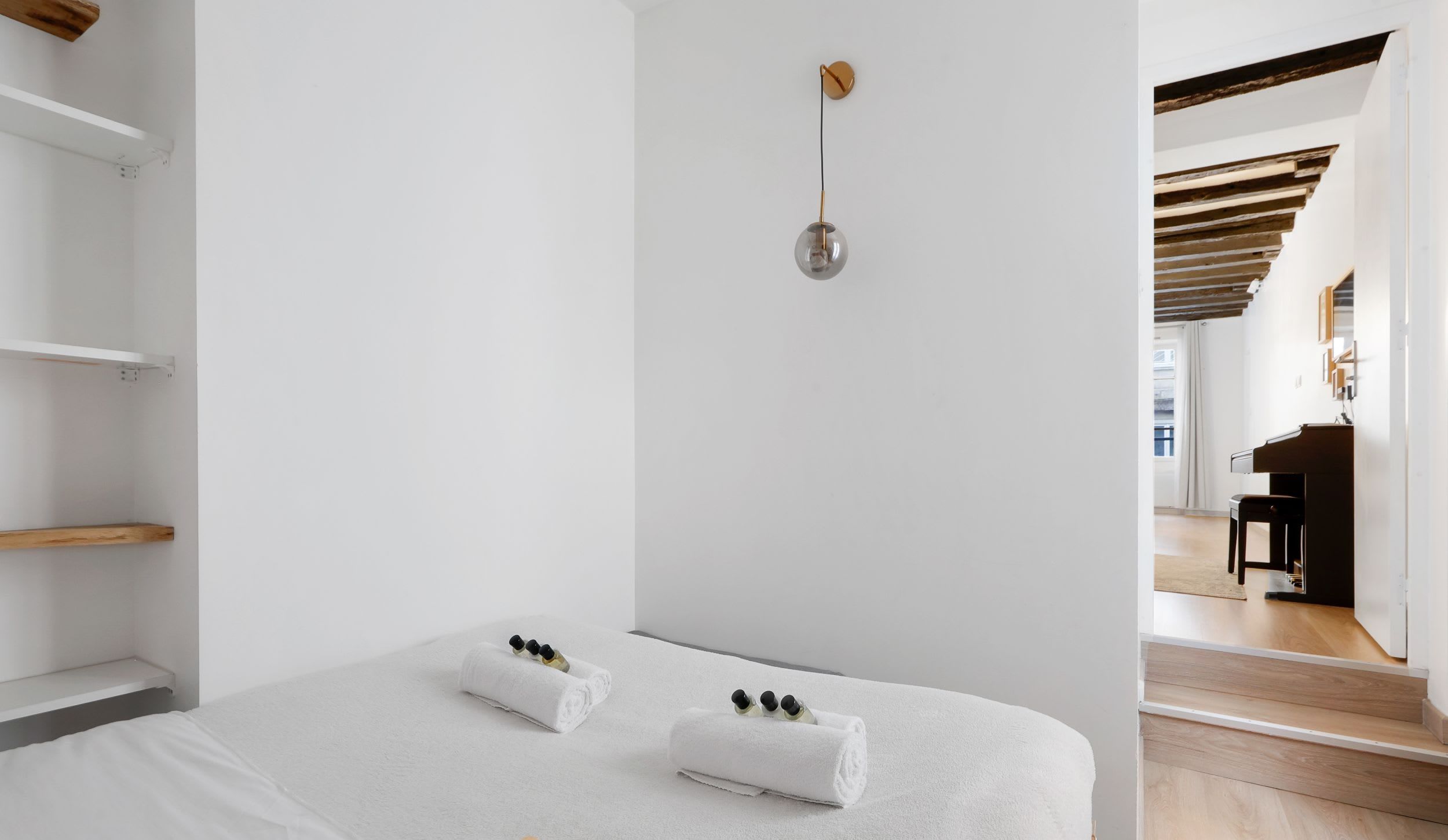 Appartement meublé rue Saint-Séverin Paris 5e, canapé-lit sous des poutres apparentes dans un intérieur du Quartier Latin