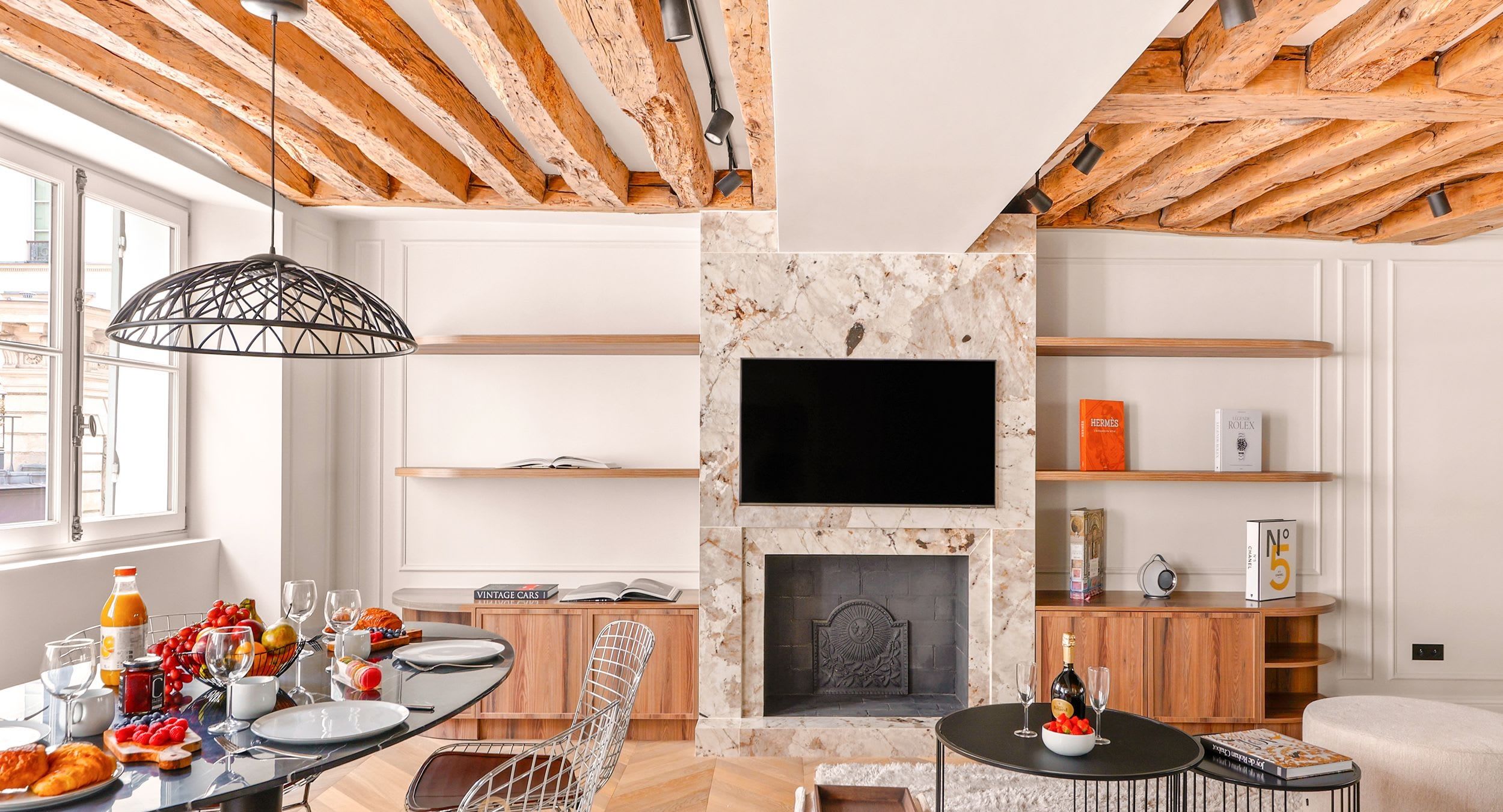 Salon avec poutres de chêne apparentes, cheminée de marbre et canapés en bouclette dans un appartement deux chambres rénové quai Malaquais, Saint-Germain, Paris 6e