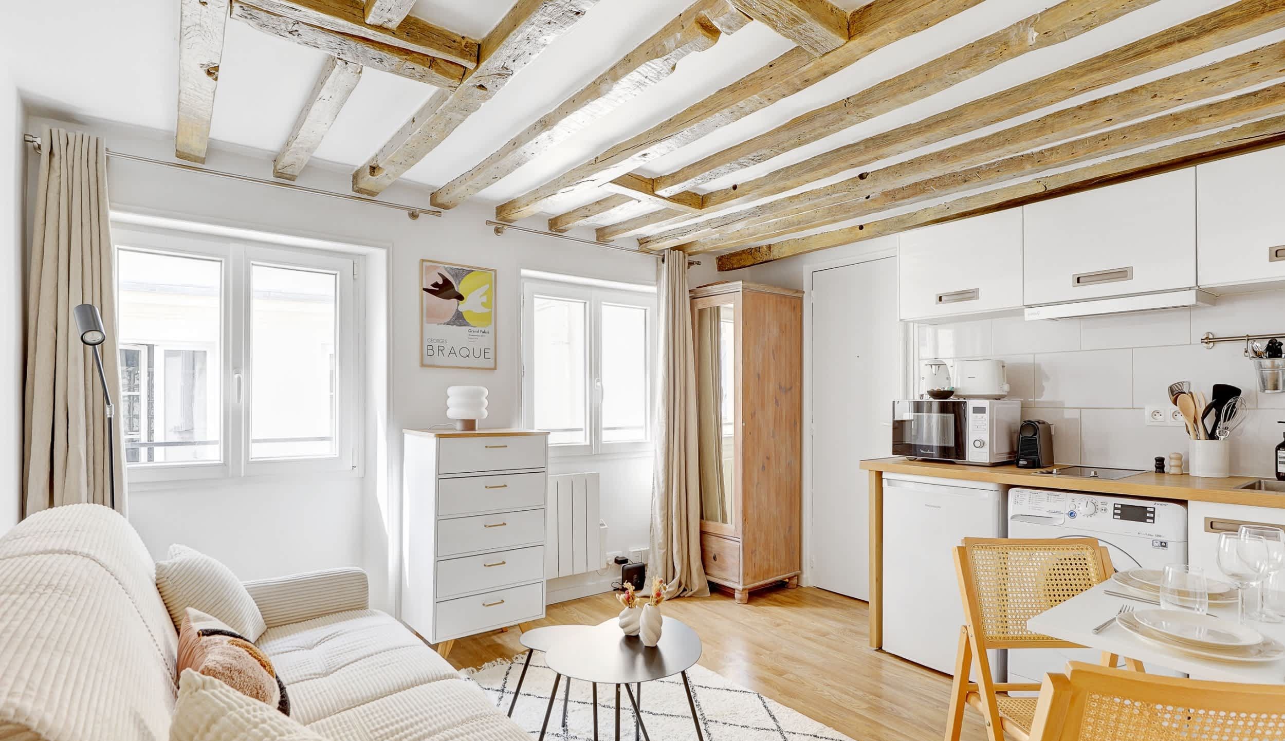 Welcome to our living room, open onto the kitchen, featuring a comfortable sofa bed, a dining corner and a TV.
