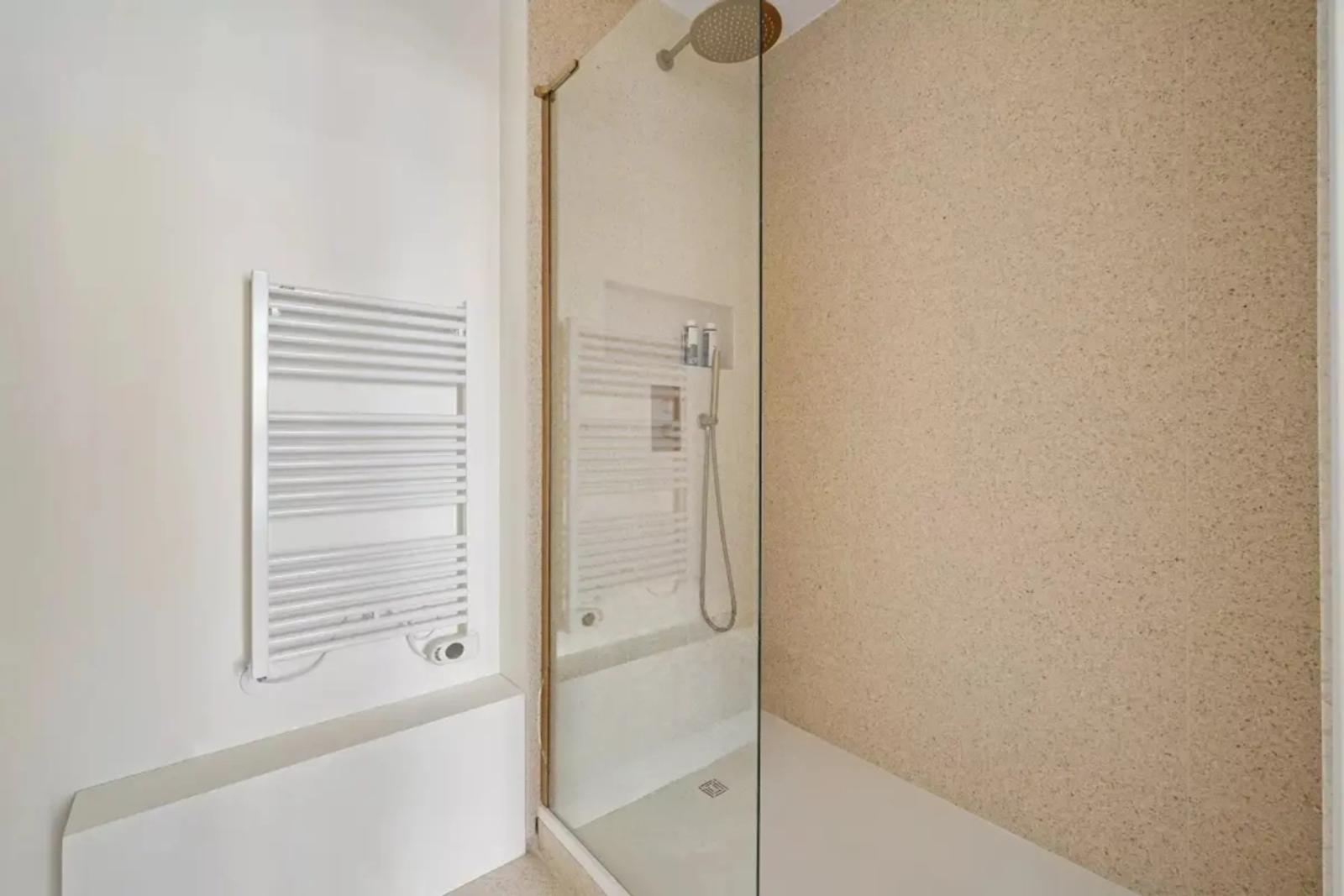 Salle d'eau avec douche vitrée et sèche-serviettes