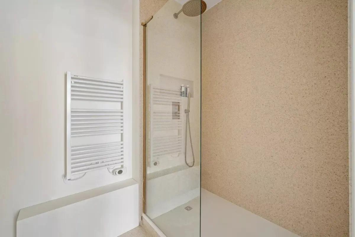 Salle d'eau avec douche vitrée et sèche-serviettes
