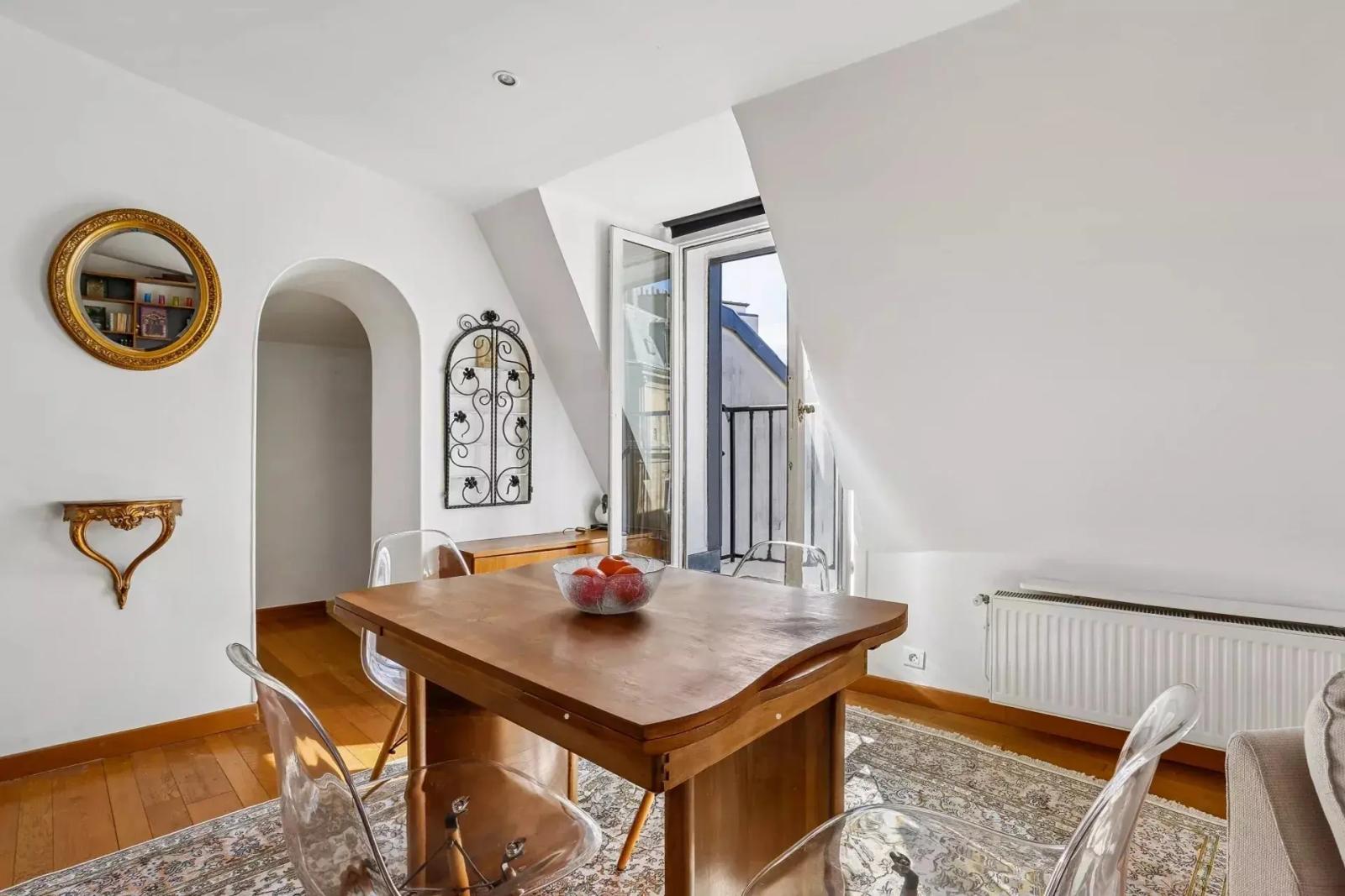Coin repas avec table en bois et passage voûté