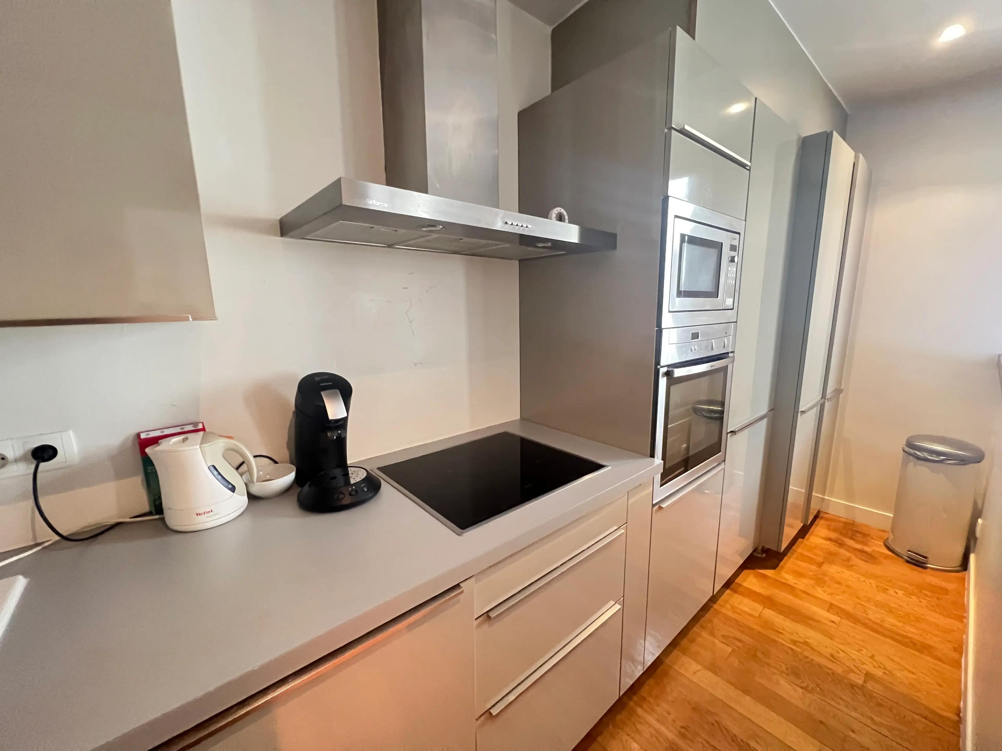 Elegant 2-bedroom apartment for rent rue Saint-Didier Chaillot Paris 16e, bright living room with mouldings, point de Hongrie parquet and semi-open kitchen