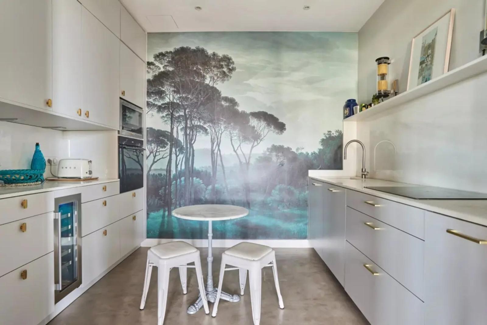 Cuisine moderne blanche avec fresque forestière
